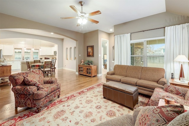 living room featuring ceiling fan, sink, and light hardwood / wood-style flooring