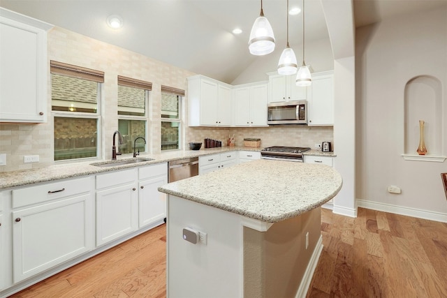 kitchen with white cabinetry, appliances with stainless steel finishes, a center island, and sink