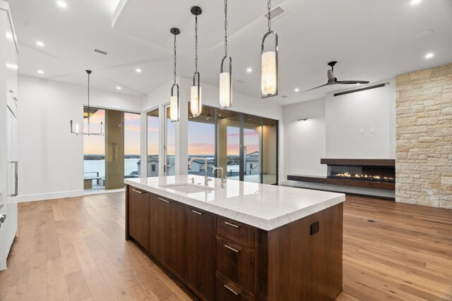 1409 Apache Tears, Horseshoe Bay, TX 78657 - kitchen with a ceiling fan, light wood-type flooring, a center island with sink, dark brown cabinetry, and recessed lighting