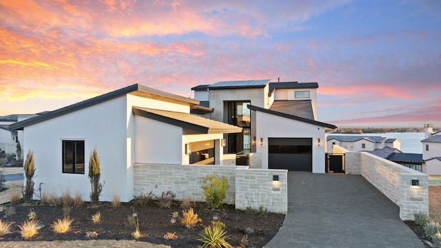 1409 Apache Tears, Horseshoe Bay, TX 78657 - modern home with decorative driveway, an attached garage, stucco siding, and stone siding