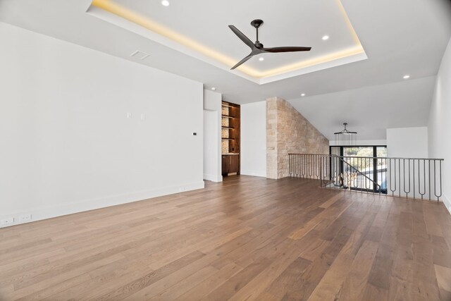 1409 Apache Tears, Horseshoe Bay, TX 78657 - unfurnished living room featuring ceiling fan, a raised ceiling, wood finished floors, and recessed lighting