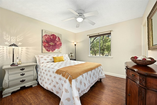 bedroom with ceiling fan, dark hardwood / wood-style floors, and a textured ceiling