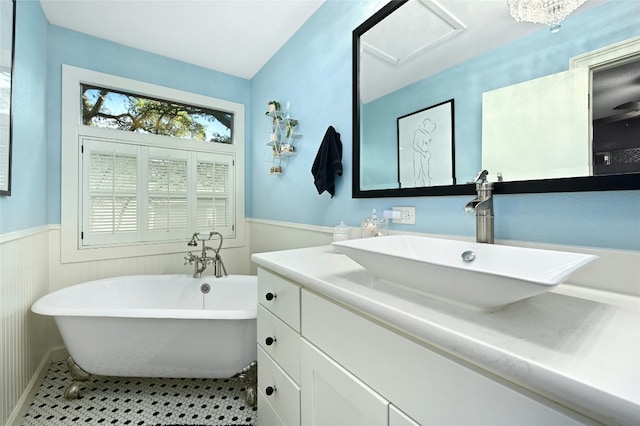 bathroom with tile patterned flooring, vanity, and a bath