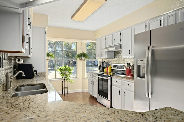 kitchen with appliances with stainless steel finishes, sink, and white cabinets