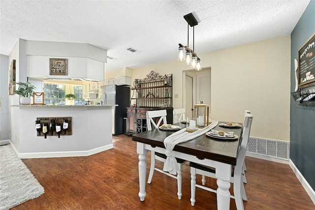 dining room with dark hardwood / wood-style flooring and a textured ceiling