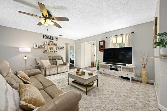 living room with ceiling fan and a textured ceiling