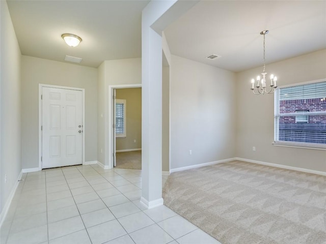 carpeted entrance foyer with a chandelier