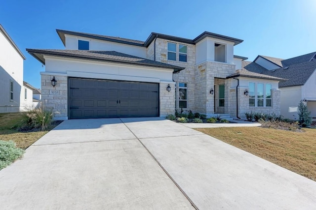 view of front of house featuring a front lawn, an attached garage, stone siding, and driveway