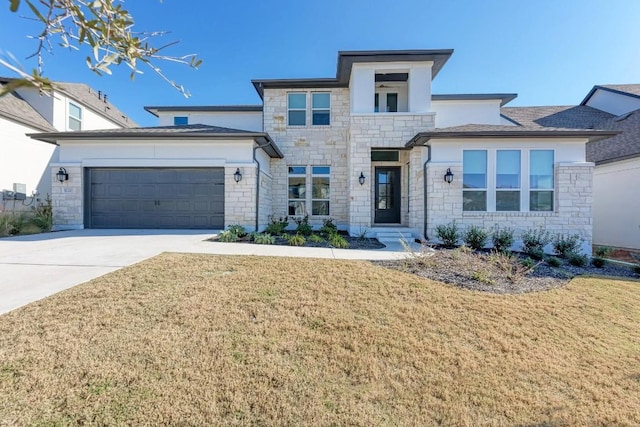 prairie-style house featuring concrete driveway, a garage, a front lawn, and stone siding