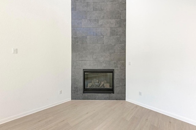 details with a tile fireplace and hardwood / wood-style floors