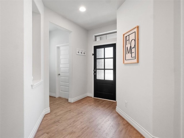 foyer entrance with light wood finished floors, baseboards, and recessed lighting