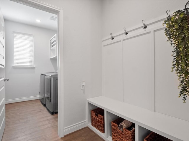 mudroom with light wood-style floors, baseboards, and washing machine and clothes dryer