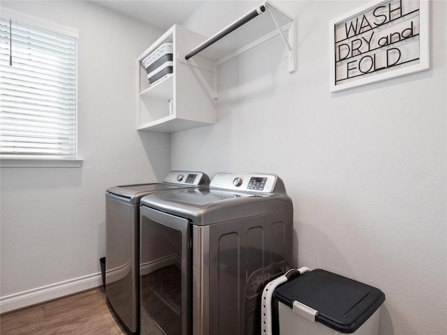 laundry area featuring laundry area, washer and clothes dryer, baseboards, and wood finished floors