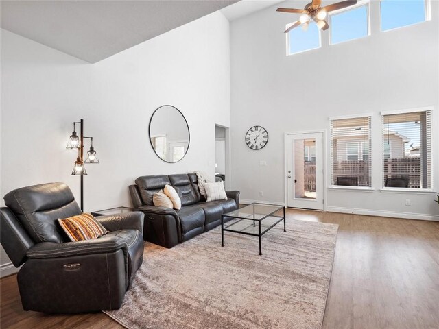 living area with ceiling fan, baseboards, and wood finished floors