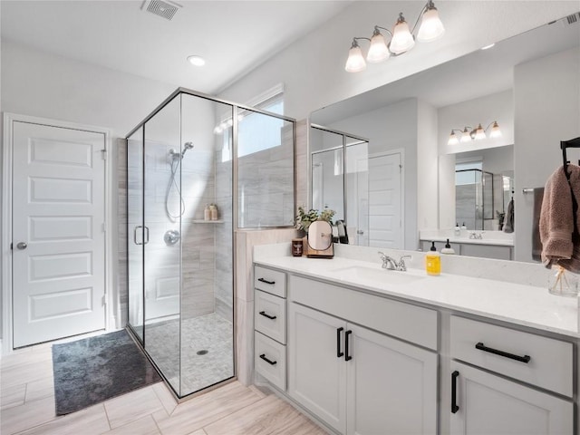 full bath featuring a stall shower, visible vents, and vanity