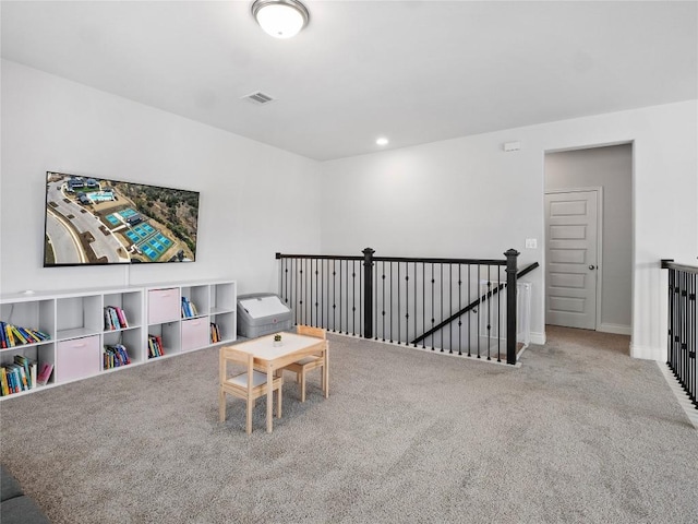 living area with visible vents, baseboards, an upstairs landing, carpet floors, and recessed lighting