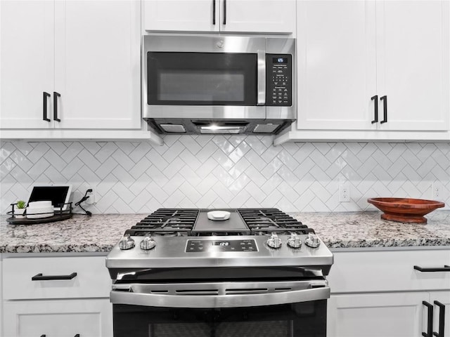 kitchen with appliances with stainless steel finishes, white cabinetry, and decorative backsplash