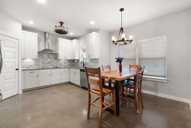 dining space featuring a chandelier and concrete floors