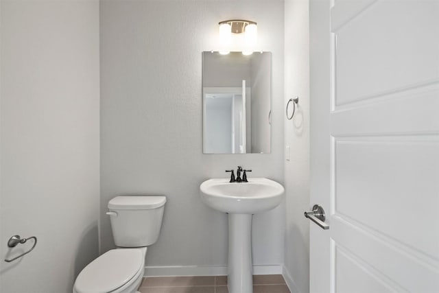 bathroom featuring sink, toilet, and tile patterned flooring