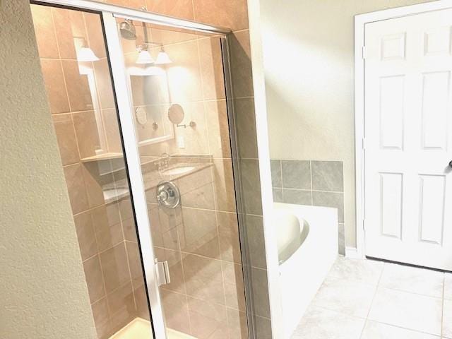 bathroom featuring shower with separate bathtub and tile patterned flooring