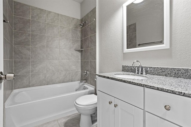 full bathroom featuring vanity, toilet, tiled shower / bath combo, and tile patterned flooring