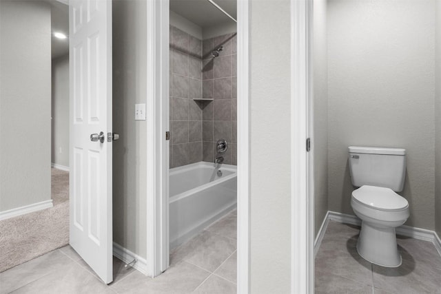 bathroom featuring tile patterned floors, toilet, and tiled shower / bath combo