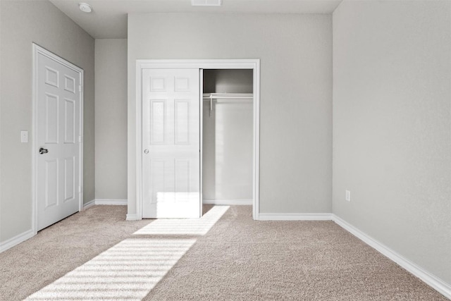 unfurnished bedroom featuring carpet floors and a closet