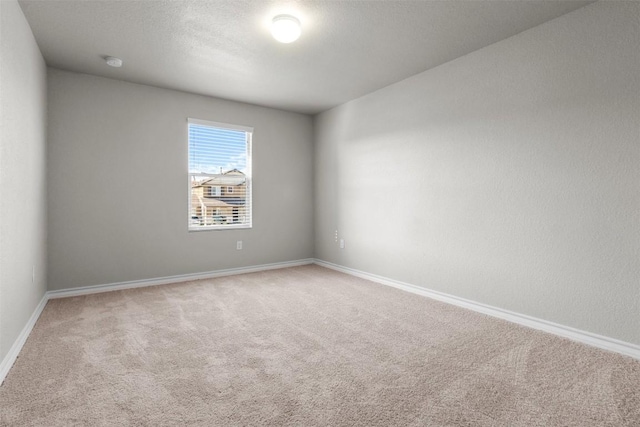 carpeted empty room featuring a textured ceiling