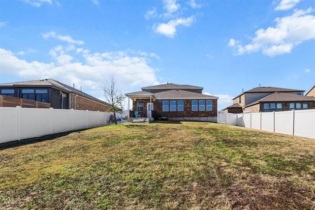 rear view of property featuring a lawn