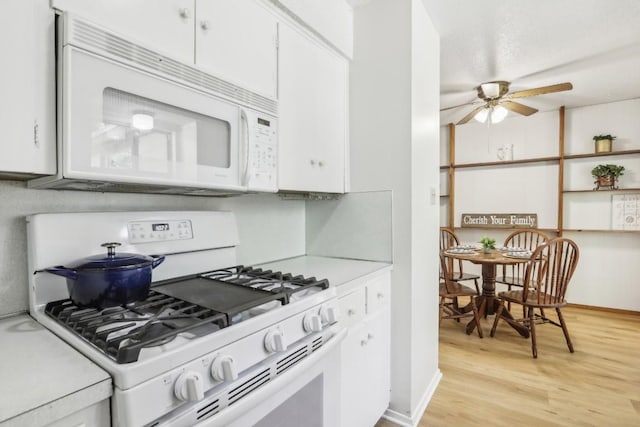 kitchen with ceiling fan, white appliances, light wood-type flooring, and white cabinets