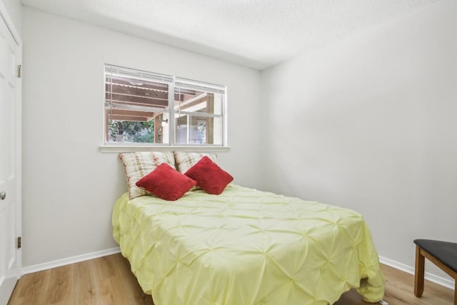 bedroom with wood-type flooring and a textured ceiling