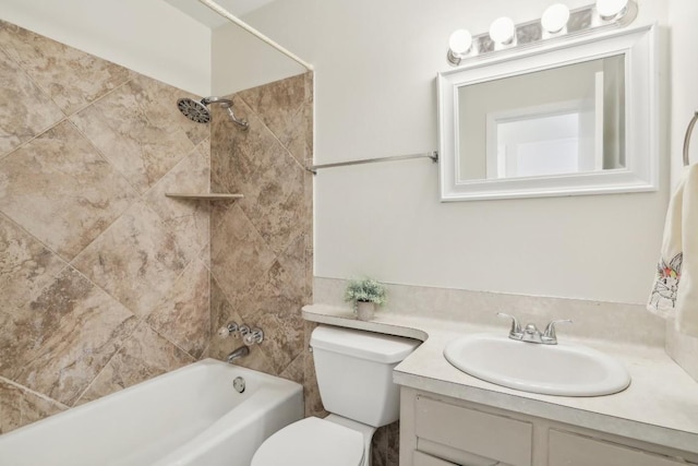 full bathroom featuring tiled shower / bath, vanity, and toilet