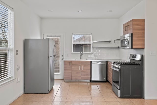 kitchen featuring light tile patterned flooring, stainless steel appliances, sink, and decorative backsplash