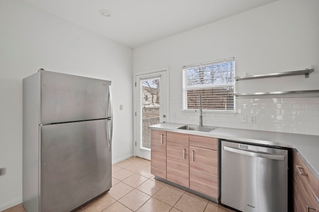 kitchen featuring light tile patterned flooring, appliances with stainless steel finishes, sink, and backsplash