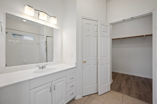 bathroom featuring tiled shower, tile patterned floors, and vanity