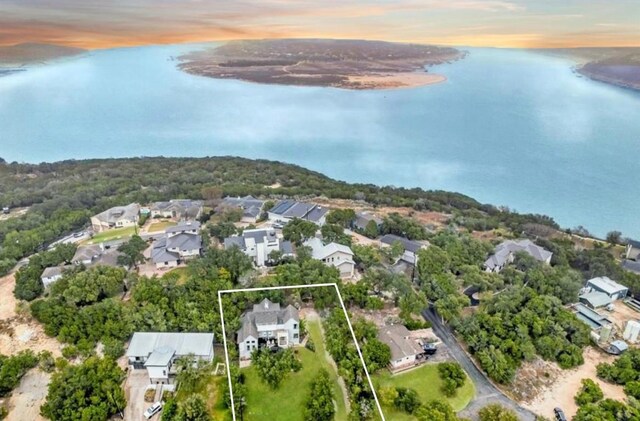 aerial view at dusk featuring a water view