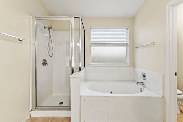 bathroom featuring tile patterned flooring, shower with separate bathtub, and toilet