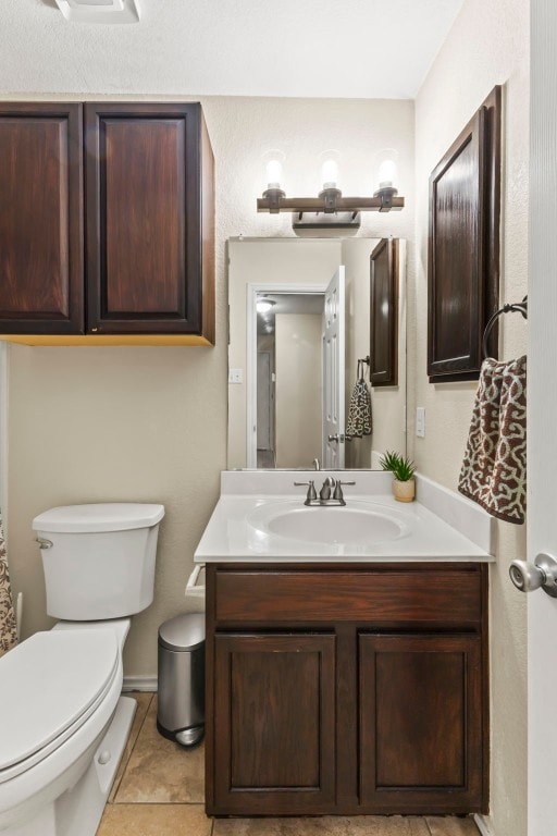 bathroom featuring vanity, tile patterned floors, and toilet