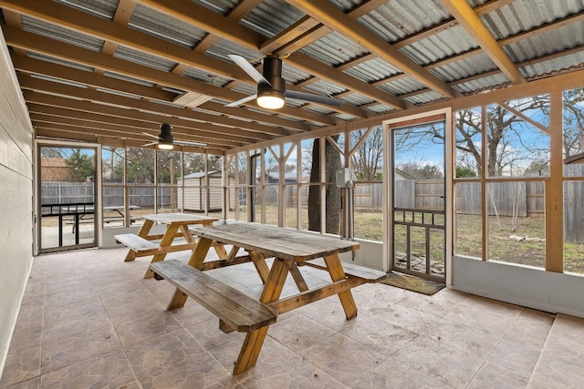 unfurnished sunroom with ceiling fan