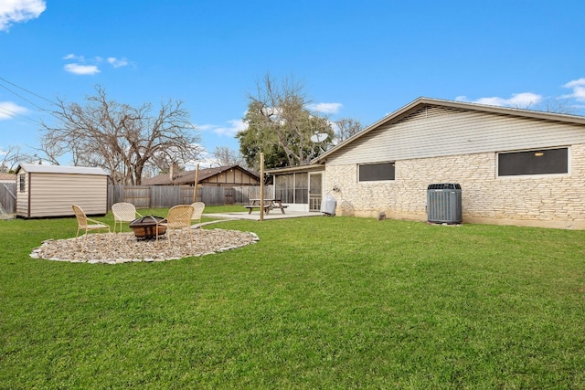 view of yard with a patio area, cooling unit, a storage unit, a fire pit, and a sunroom