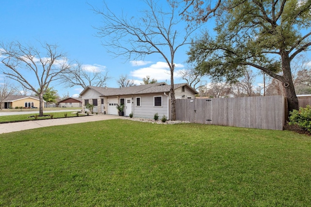 view of front of home featuring a fenced front yard, a front lawn, driveway, and an attached garage