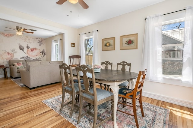 dining area with ceiling fan and light wood-type flooring