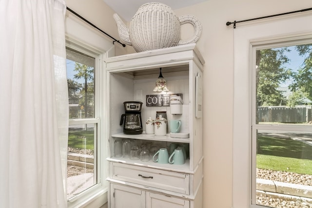 bar with white cabinetry and pendant lighting