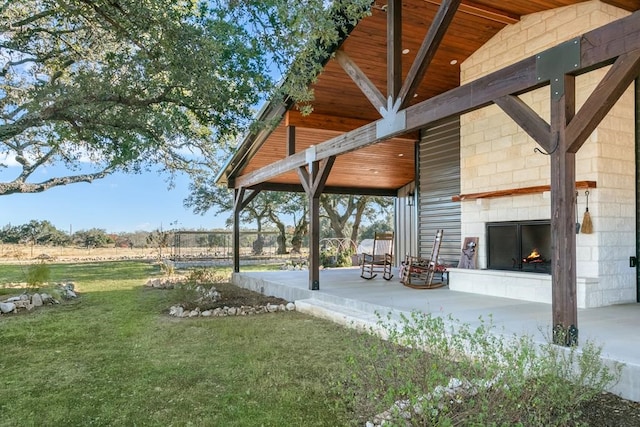 view of yard featuring a large fireplace and a patio