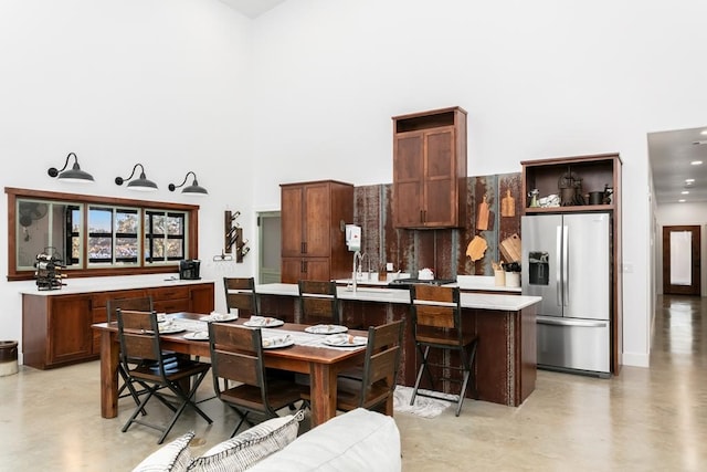 dining room with sink and a towering ceiling