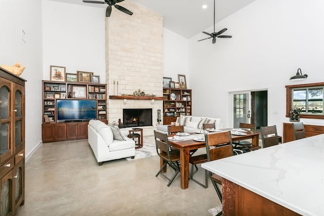 living room featuring ceiling fan, a fireplace, and high vaulted ceiling