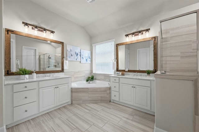 bathroom with vanity, separate shower and tub, and vaulted ceiling