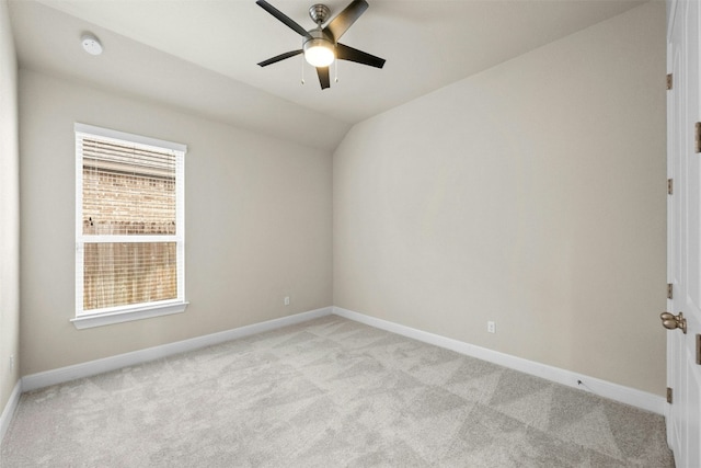 spare room featuring vaulted ceiling, light colored carpet, and ceiling fan