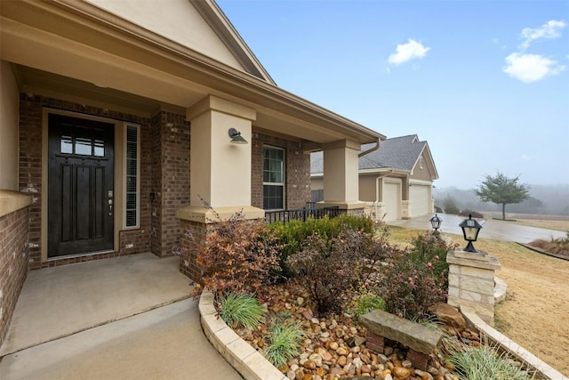 doorway to property featuring a garage and a porch