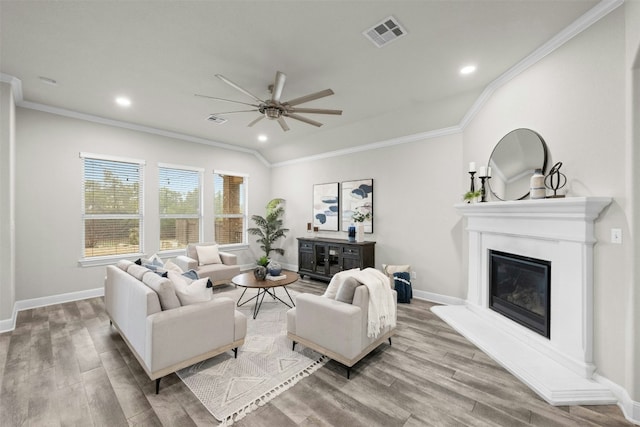 living room featuring ceiling fan, ornamental molding, light hardwood / wood-style floors, and lofted ceiling